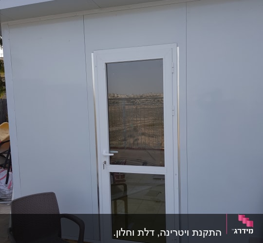 דלת אלומיניום לבנה במבנה חיצוני